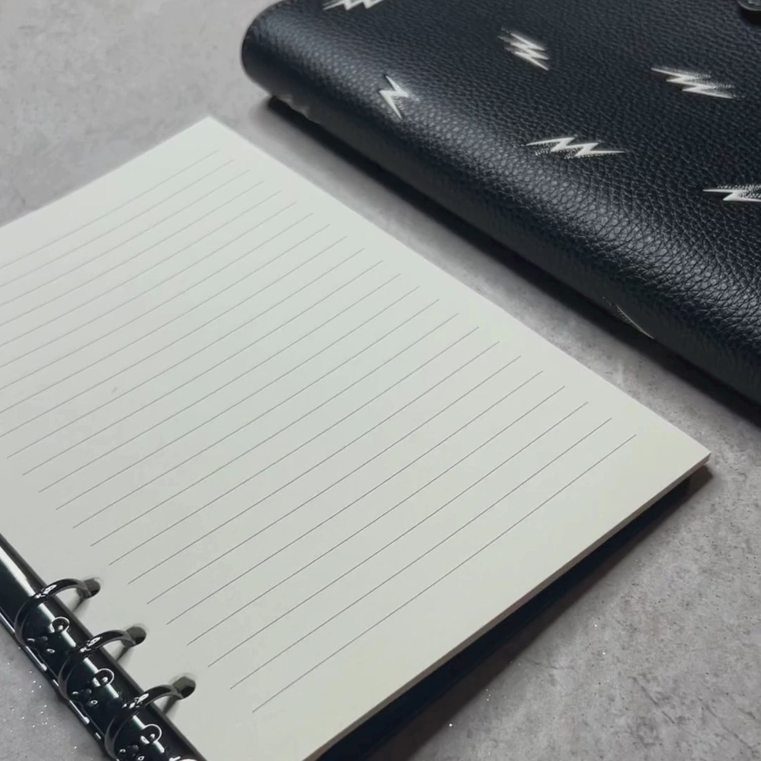 video of a 6 ring adapter made by pop in planner with a compatible Coach brand notebook cover